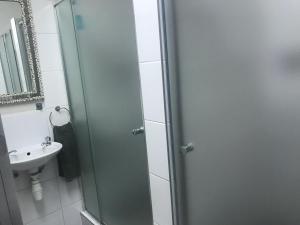 a bathroom with a glass shower door next to a sink at Wilderness Beach House Backpackers Lodge in Wilderness +86 photos