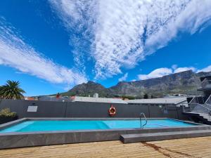 a swimming pool with a mountain in the background at Kloof Street Hotel in Cape Town