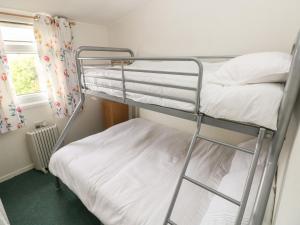 two bunk beds in a room with a window at Willow 80 in Carmarthen
