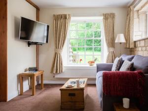 a living room with a blue couch and a window at Prince Rupert in Winchcombe