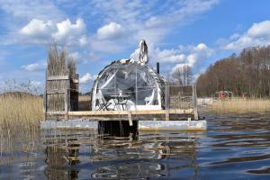 a boat sitting on top of a body of water at Gulbju māja - Swan house in Usma