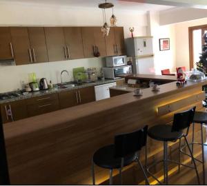 a kitchen with a bar with stools in it at Comfy 3 Room House with Garden in Istanbul
