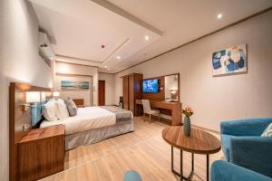 Red Sea Seasons Hotel Suites في جدة: غرفة في الفندق مع سرير ومكتب