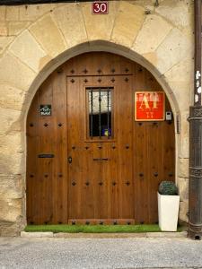 Una gran puerta de madera con un cartel. en Apartamentos Lorione, en Olite