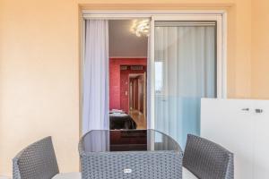 a dining room with a glass table and chairs and a mirror at Luxury studio renovated 2024 with free parking in Beausoleil