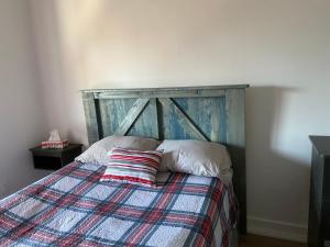 a bed with a wooden headboard in a bedroom at Gestion clin d’œil - 501 in La Tuque