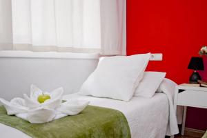 a bedroom with a white bed with a white flower on it at Barcelona City North Hostal in Barcelona