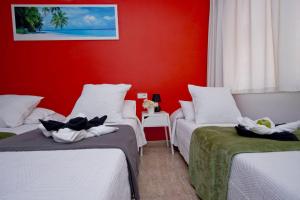 a room with two beds and a red wall at Barcelona City North Hostal in Barcelona