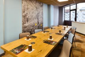 a conference room with a large wooden table and chairs at ibis Paris Gare De L Est 10ème in Paris