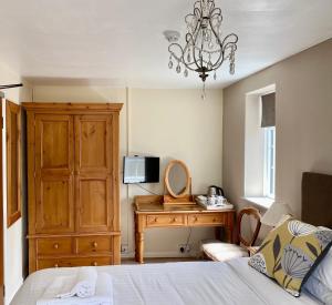 a bedroom with a bed and a dresser and a mirror at Plumpton Court in Nawton