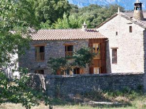 una antigua casa de piedra con una pared de piedra en El Corral de Villacampa, en Mondot