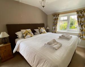 a bedroom with a large white bed with towels on it at Plumpton Court in Nawton