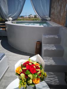 un mazzo di fiori seduto su un tavolo accanto a una vasca da bagno di Mare Nostrum Santo a Oia