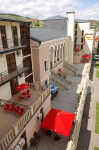 an aerial view of a building with red tables and chairs at Hotel Grand Palace in Akhaltsikhe