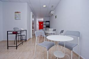 a room with tables and chairs and a red door at Barcelona City North Hostal in Barcelona
