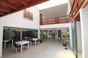 ein Restaurant mit Tischen und Stühlen und einem Balkon in der Unterkunft Pousada Cheiro Verde in Arraial d'Ajuda