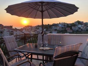uma mesa com óculos e um guarda-chuva numa varanda em Apartment Frane Podstrana with private pool em Podstrana