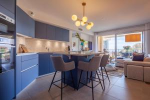 a kitchen with blue cabinets and bar stools at Monaco à pied in Beausoleil