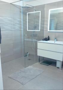 ein Bad mit einer Glasdusche und einem Waschbecken in der Unterkunft Monaco à pied in Beausoleil