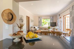 a living room with a table with a bowl of fruit on it at Aloe Cottage at Ibis House in Cape Town