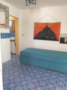 a room with a blue bed and a painting on the wall at Casa Le Due Sicilie in Panarea