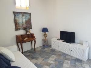 a living room with a couch and a television at Casa Le Due Sicilie in Panarea