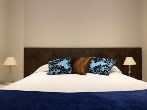 a bedroom with a large bed with two lamps at Apartamentos Lorione in Olite