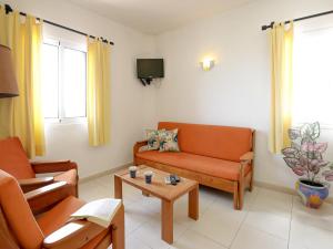 salon z pomarańczowymi meblami i telewizorem w obiekcie Praia da Oura Apartment - 100 m from the Beach - By Bedzy w Albufeirze