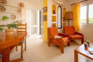 salon z pomarańczowymi krzesłami i stołem w obiekcie Praia da Oura Apartment - 100 m from the Beach - By Bedzy w Albufeirze