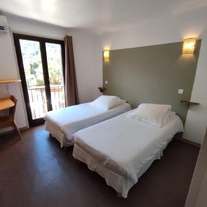 two beds in a hotel room with a window at Le monte rosso in Porto Ota
