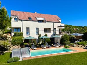 un bâtiment avec une piscine en face d'une maison dans l'établissement Panoráma Apartmanház, à Balatonfüred