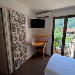 a bedroom with a desk and a bed and a window at Le monte rosso in Porto Ota