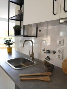 a kitchen counter with a sink and a wooden spoon at Pateo Estoril - Brand New Villa in Estoril in Estoril +144 photos