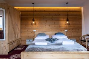 Rzepiskaにあるudanypobyt Dom Forest Prestige Houseの木製の壁に大きなベッドが備わるベッドルーム1室