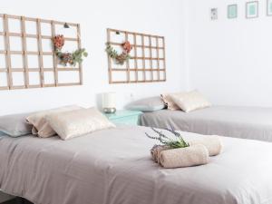 two beds with towels on them in a room at Alfaros in Córdoba