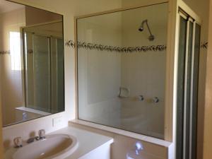 a bathroom with a shower, sink, and tub at Country Rose Motel Warwick in Warwick