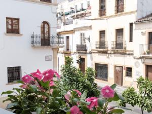 a building with pink flowers in front of it at Alfaros in Córdoba