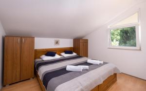 ein Schlafzimmer mit zwei Betten und einem Fenster in der Unterkunft Apartments Katica in Mlini