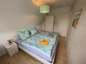 een kleine slaapkamer met een bed met een geel shirt erop bij Lust auf Meer - Ferienwohnung in Cuxhaven +14 foto's
