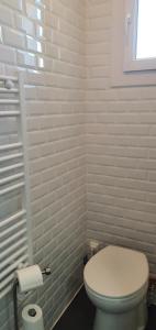 une salle de bain blanche avec toilettes et fenêtre dans l'établissement Appartement avec terrasse quartier Montplaisir, à Arles 11 autres photos