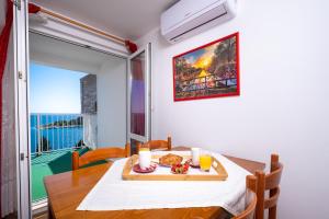 ein Esszimmer mit einem Tisch mit einem Teller Essen drauf in der Unterkunft Apartments Katica in Mlini