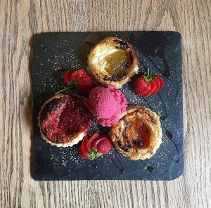 eine schwarze Platte mit Erdbeeren und Desserts darauf in der Unterkunft Peak Hotel Castleton in Castleton