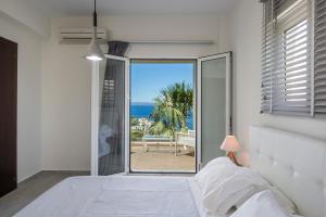 a bedroom with a bed and a view of the ocean at Villa Nicolas Plaka With Sea View in Plaka