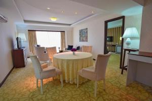 a living room with a round table and chairs at Hotel Izgrev Spa & Aquapark in Struga