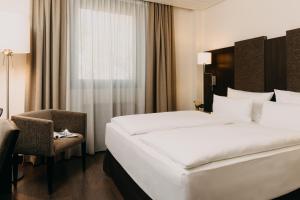 a hotel room with a bed and a chair at Hotel Forsthaus Nürnberg Fürth in Fürth +97 photos