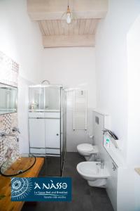 a white bathroom with two toilets and a sink at Bed & breakfast La Nassa in Taranto