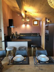 a kitchen with a table and some chairs and a counter at Chalet Hibou in Les Deux Alpes