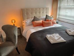 a bedroom with a large bed and a chair at The Lion in Broseley