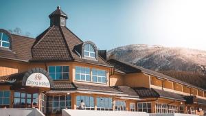 a large building with a mountain in the background at Grong Hotell in Grong
