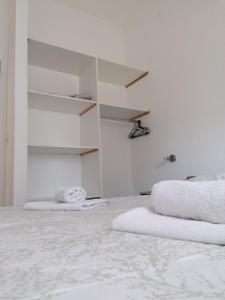 - une chambre blanche avec des serviettes blanches à l'étage dans l'établissement Apartments Maričić, à Zaton